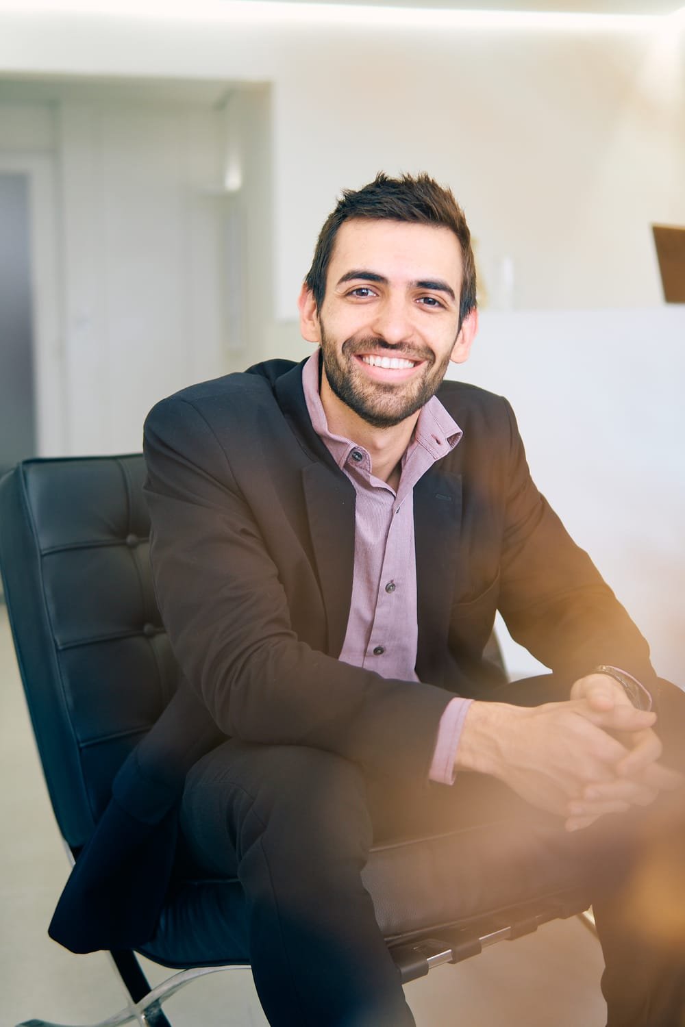 Dr. Henrique Alessi sorrindo, sentado no consultório